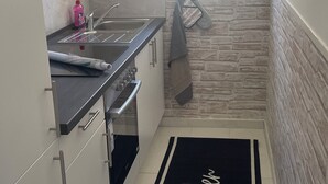 Una cuina petita amb finestra, fogó i rentatge.