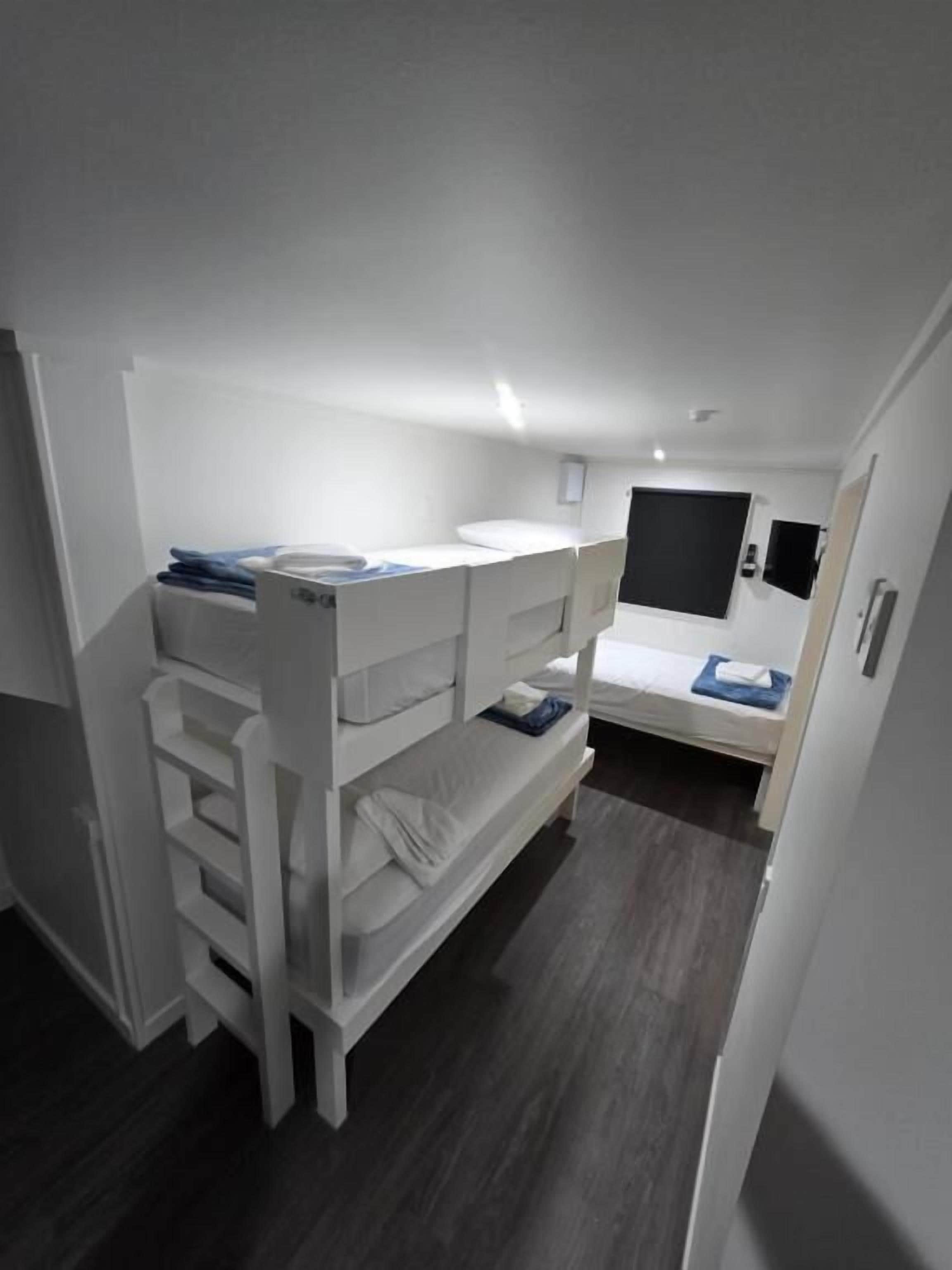 Dormitorio con literas, un escritorio y una cama pequeña.