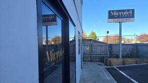 A building with a sign for 'Microtel Lodge' and a contact number. - Microtel Lodge (Hamilton)
