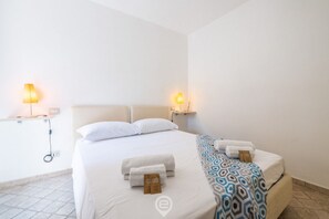 Une chambre d’hôtel avec un lit, deux lampes de chevet et un porte-serviettes.