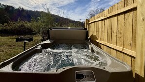 Un jacuzzi con una valla de madera y un buzón al frente.