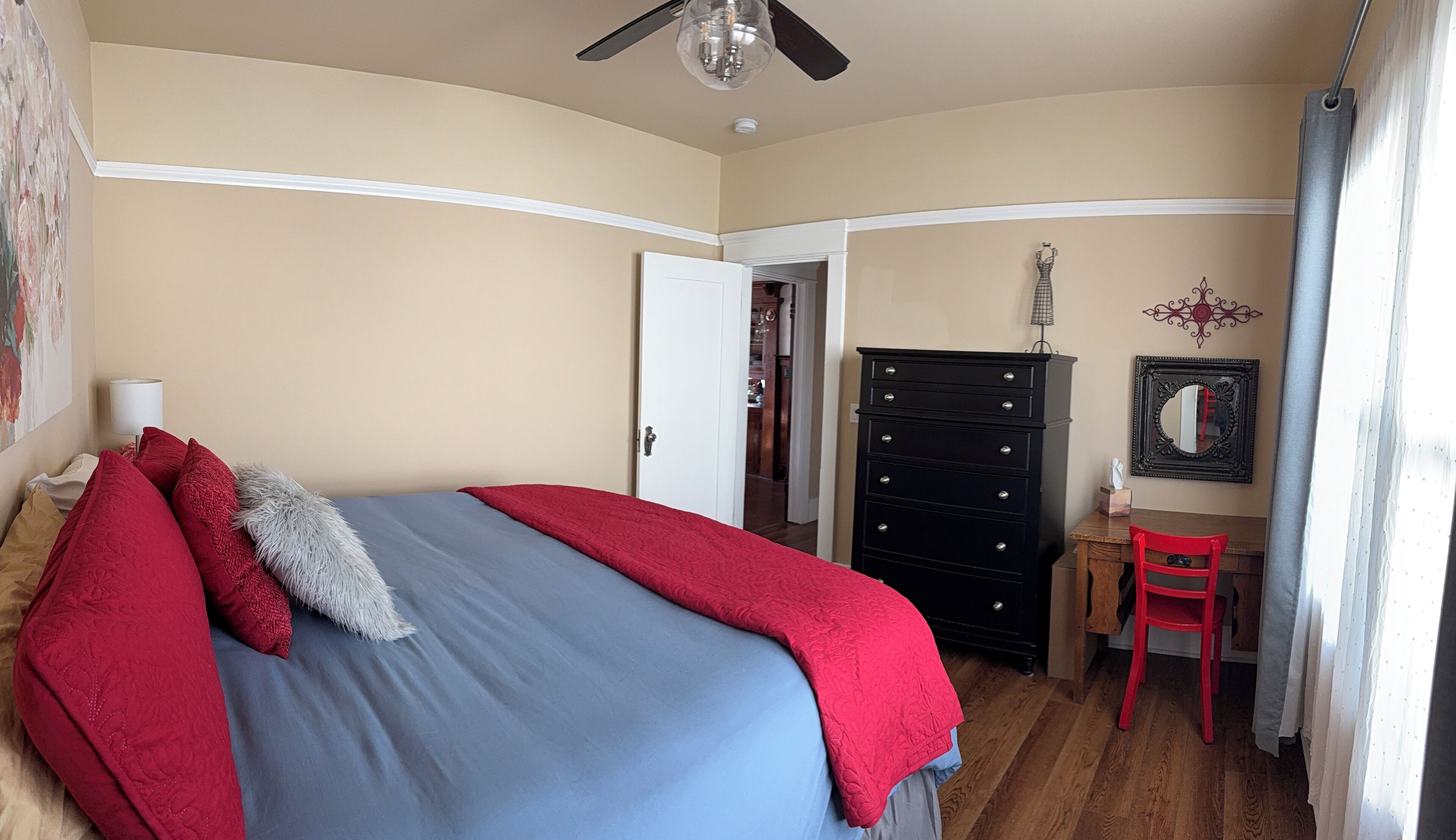 A bedroom with a bed, a dresser, a desk, and a chair.