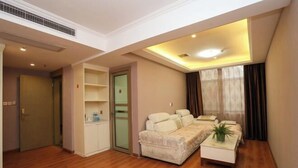 Una sala de estar con un sofá, una mesita con una planta, un armario y una puerta corredera.
