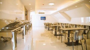 Un comedor moderno con mostradores tipo buffet de acero inoxidable y sillas contemporáneas.