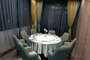 A round dining table with six chairs, set for a meal with plates, glasses, and a centerpiece. - Taoran Hotel (Beijing)
