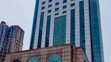 A tall building with a modern design, featuring a mix of glass and concrete materials.