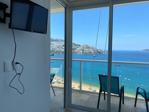 Enjoy breathtaking views of the sea from the balcony, featuring a flat-screen TV and two comfortable chairs.