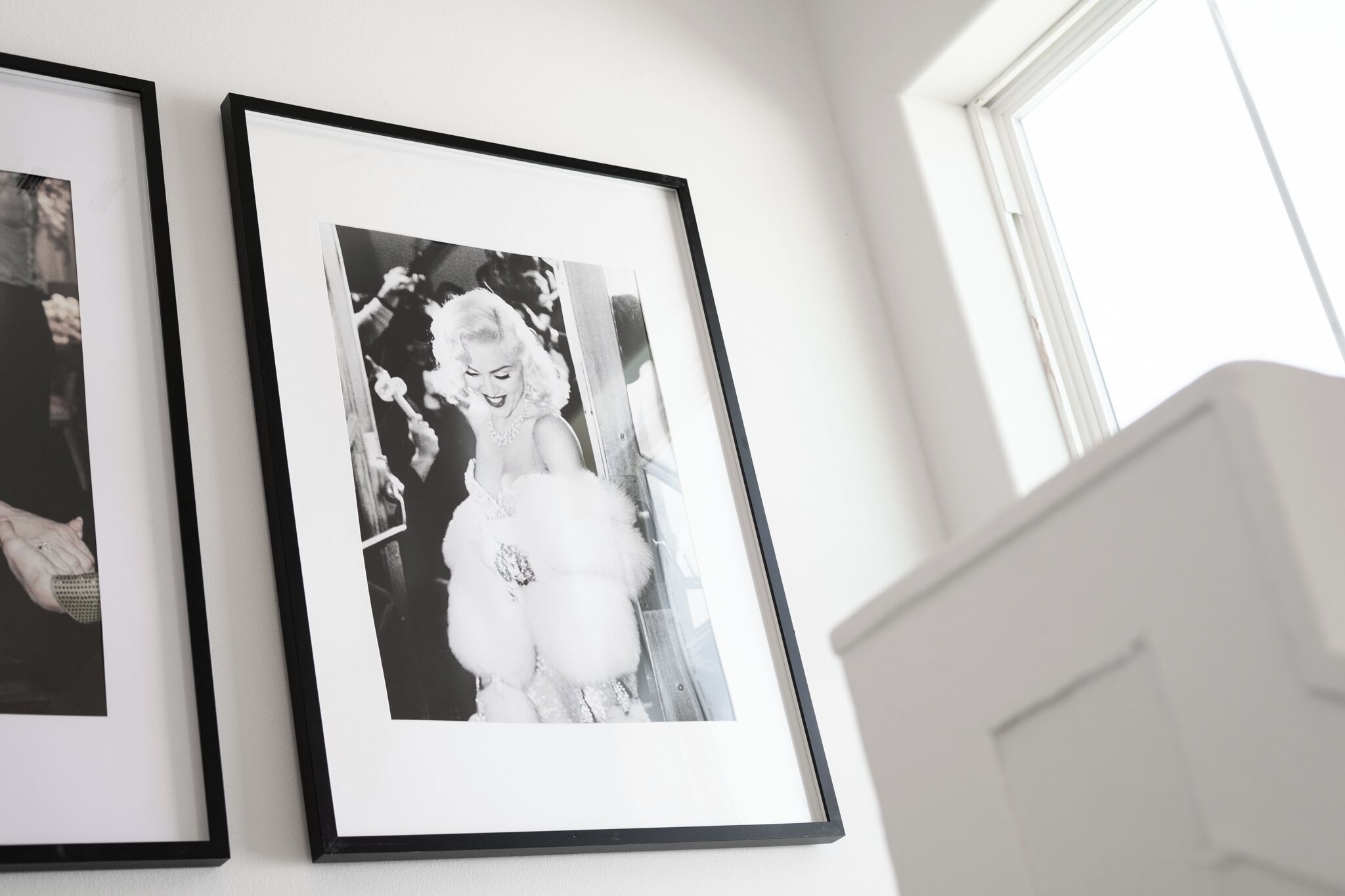 Two framed black and white photographs on a wall.