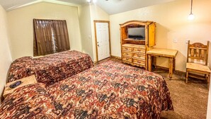 A bedroom with two beds, a wooden dresser, a desk, and a ceiling fan. - Cozy cabin with AC and WiFi in peaceful Sterling City.  Your small town adventure awaits! (Sterling City)