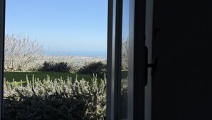 A view through a window with a door frame, a grassy area, and a distant landscape. -  PP03 - Potenza Picena, wonderful villa with sea view (Potenza Picena)