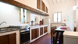A kitchen with a stove, oven, sink, and wooden cabinets. -  PP03 - Potenza Picena, wonderful villa with sea view (Potenza Picena)