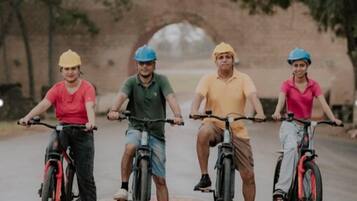 Vier personen fietsen op een geplaveid pad met een versiering.