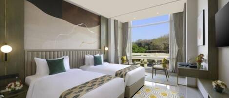 A modern hotel room with two beds, a large window with a view, a desk, and a TV.