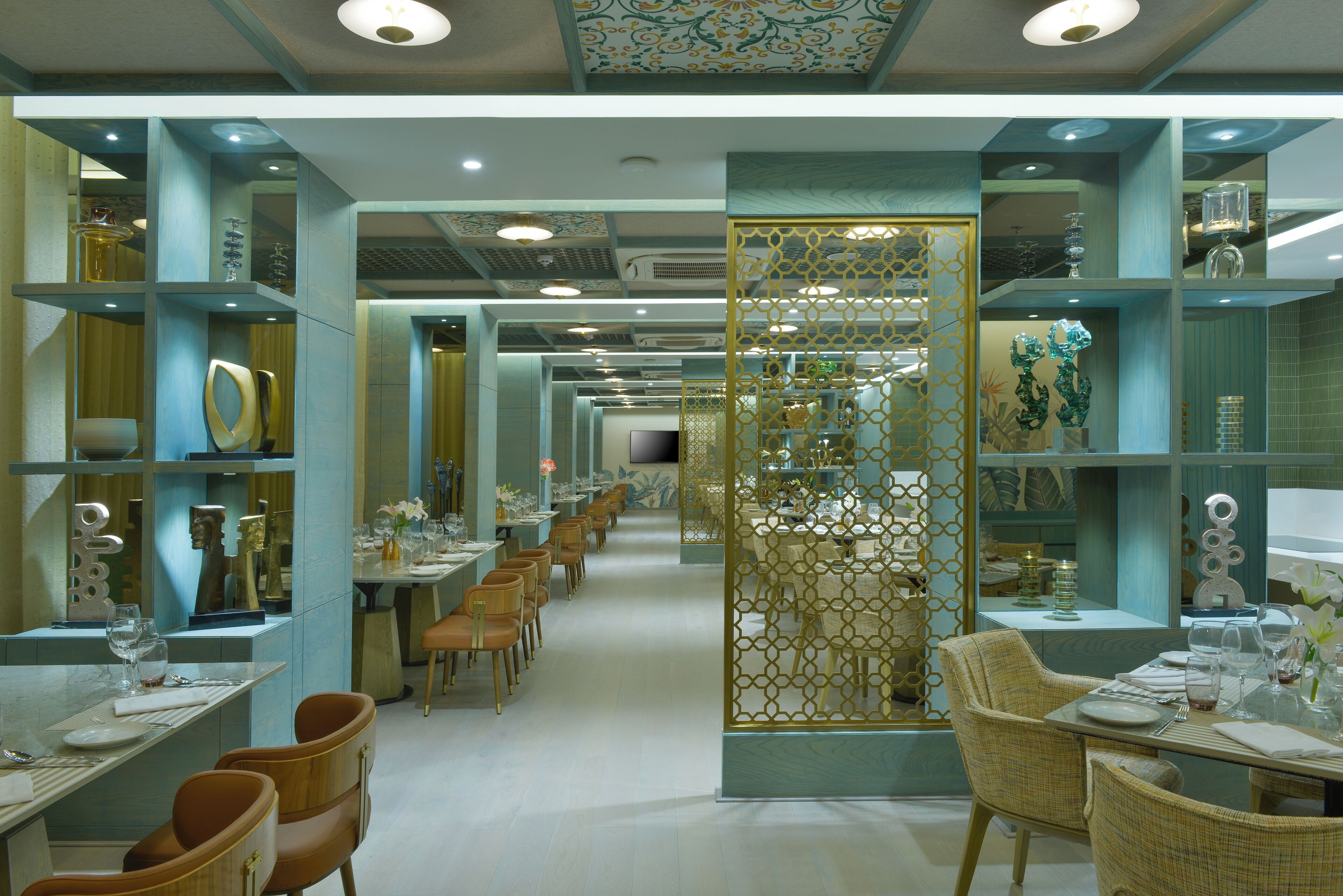 A modern restaurant with a long dining area, multiple tables, and chairs.