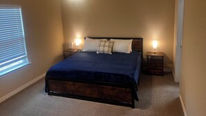A bedroom with a bed, two bedside tables, a ceiling fan, and a window with blinds. - Cozy 3BR Home in Poolville / AC + Fast WiFi / Relaxing Escape (Poolville)