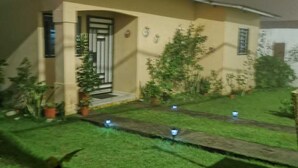 A residential house with a well-maintained lawn and potted plants. - Copeyhousechiriquí (Volcán)