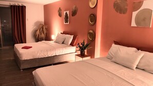 Une chambre d’hôtel avec deux lits, une table de chevet et des œuvres d’art décoratives au mur.