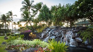 A waterfall, tropical plants, and a sign for Ko Olina Resort. - Bright & Spacious 2br/2ba Villa-Ko'Olina Resort (Kapolei)