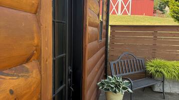 A wooden log building with a sign reading 'Orchard Room,' a bench, and a potted plant.