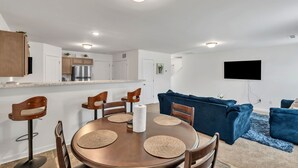 Una cocina moderna con armarios blancos, un refrigerador de acero inoxidable y un horno empotrado.