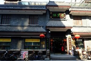A traditional building with a signboard, bicycles parked outside, and a red lantern. - Shanghai Yaya Light Luxury Hotel (Hongkou Football Stadium) (Shanghai)