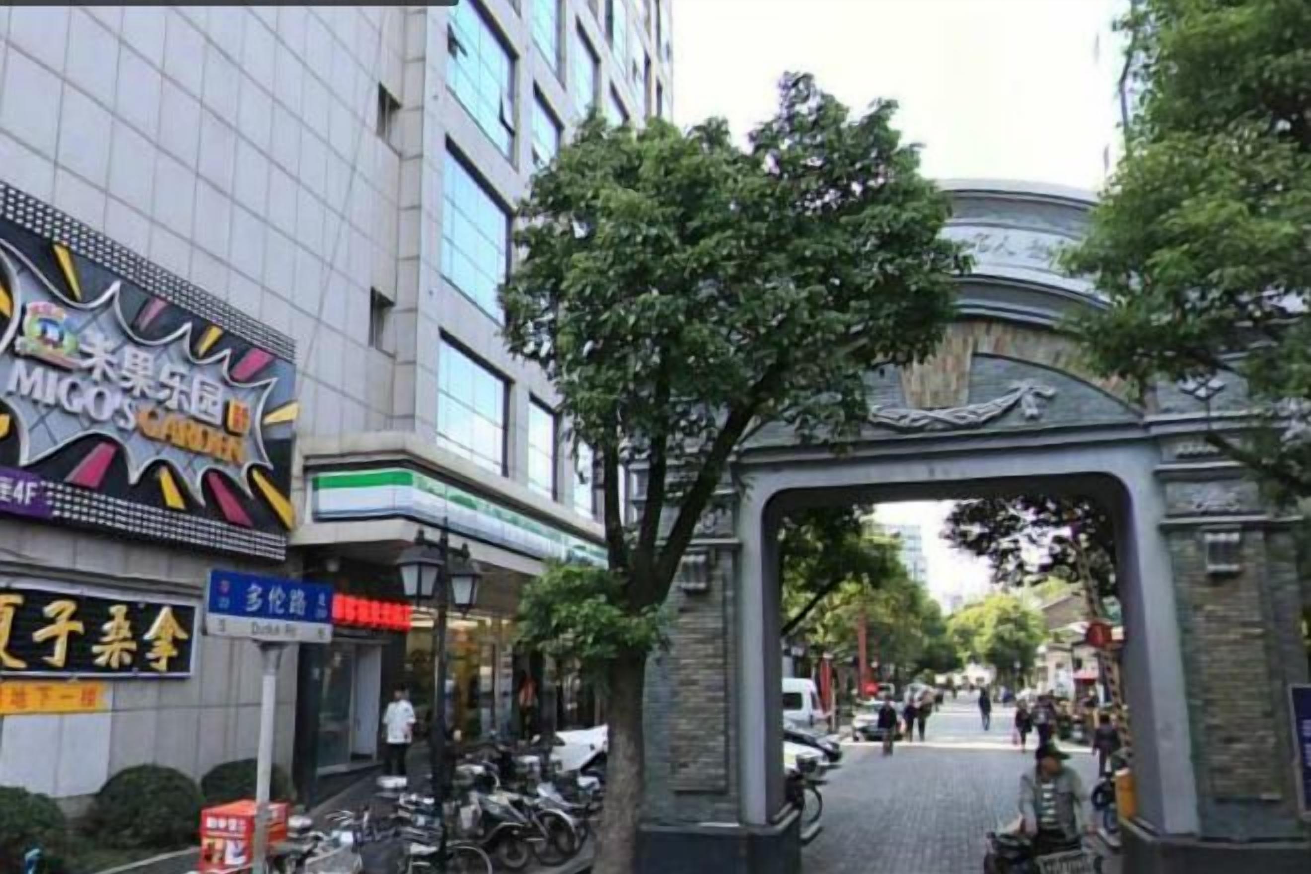 Una calle con un arco tradicional, un letrero de restaurante y motocicletas estacionadas.
