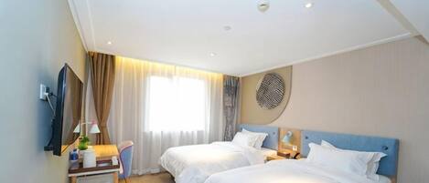 A hotel room with two beds, a desk, a TV, and a large window.