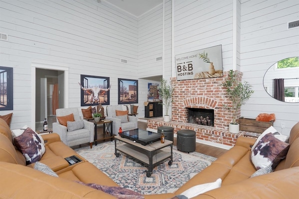 Una sala de estar amplia con chimenea, un conjunto de sofás y una mesa de centro.