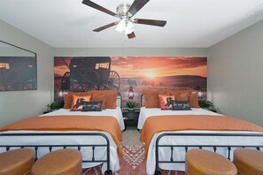 A bedroom with two beds, a ceiling fan, and a sunset painting on the wall. - Abilene Icon- Sky, Story, and the Western Spirit! (Abilene)