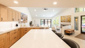 Una cocina moderna con armarios de madera, encimera de mármol y una isla grande.
