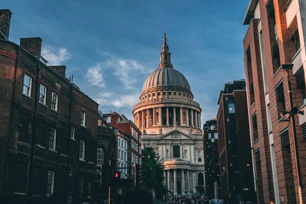 A historic building with a prominent dome, surrounded by modern buildings.