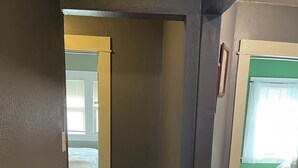 A hallway with wooden flooring and a corner with a dark wall. - 3-bedroom duplex yellow house downtown  Des Moines with AC, WiFi (des moines)