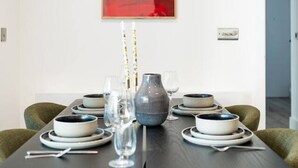 Une table à manger avec des chaises, un vase et de la verrerie.