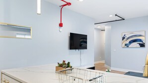 A modern kitchen with a marble countertop, a built-in sink, and a red pendant light. - Charming 2-bedroom apartment in fabulous Westchester with AC, WiFi (Westchester)