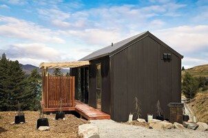 Un edificio moderno con una terraza de madera y un letrero que dice "THE HUTS".