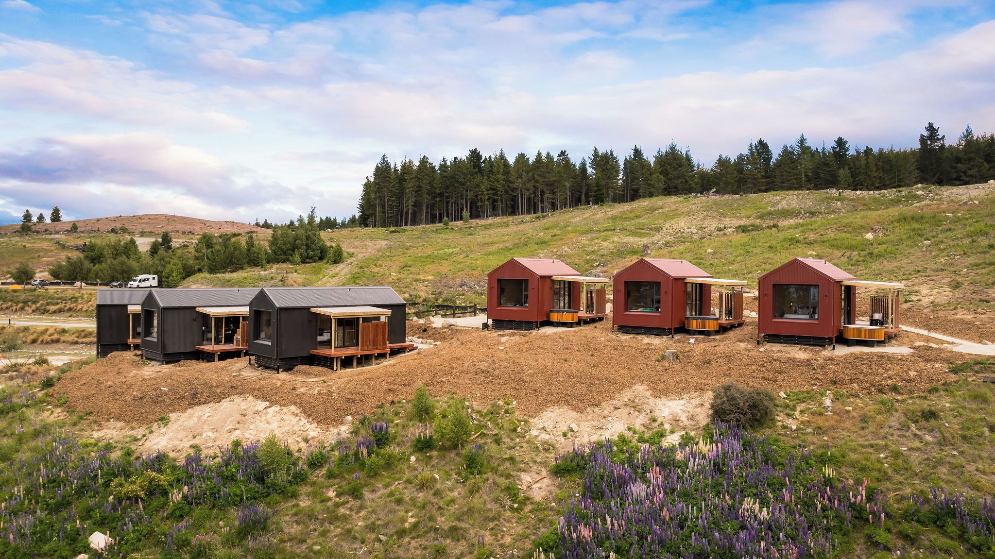 Une rangée de cabanes avec une terrasse en bois, un petit porche et une fenêtre.