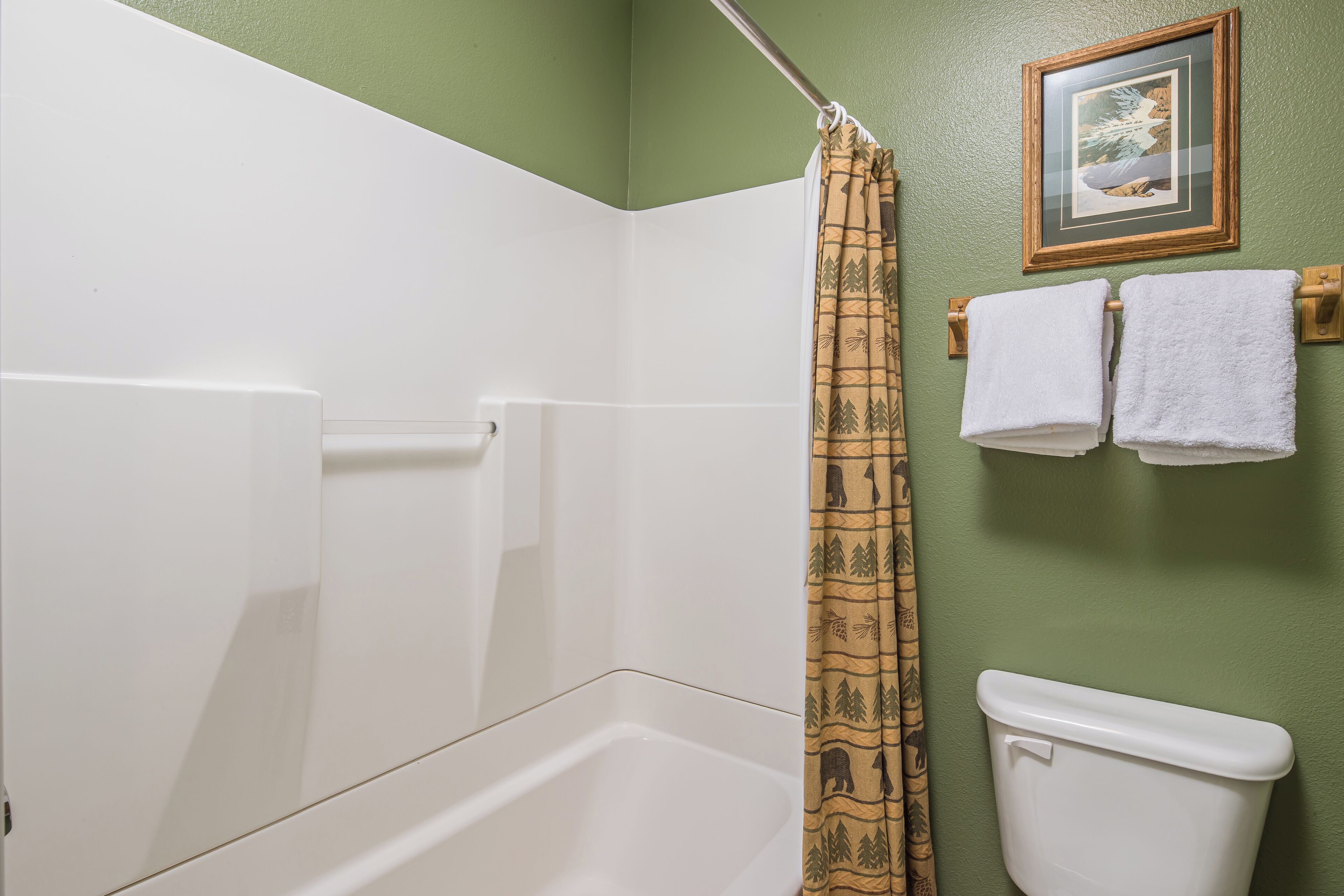 Un baño con ducha, inodoro y toallero.