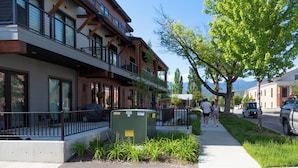 A multi-story building with balconies, a sidewalk, and a parked vehicle. - Located in Downtown Whitefish,Walk to Dining and Shops- Nearby Lake and Ski! (Whitefish)