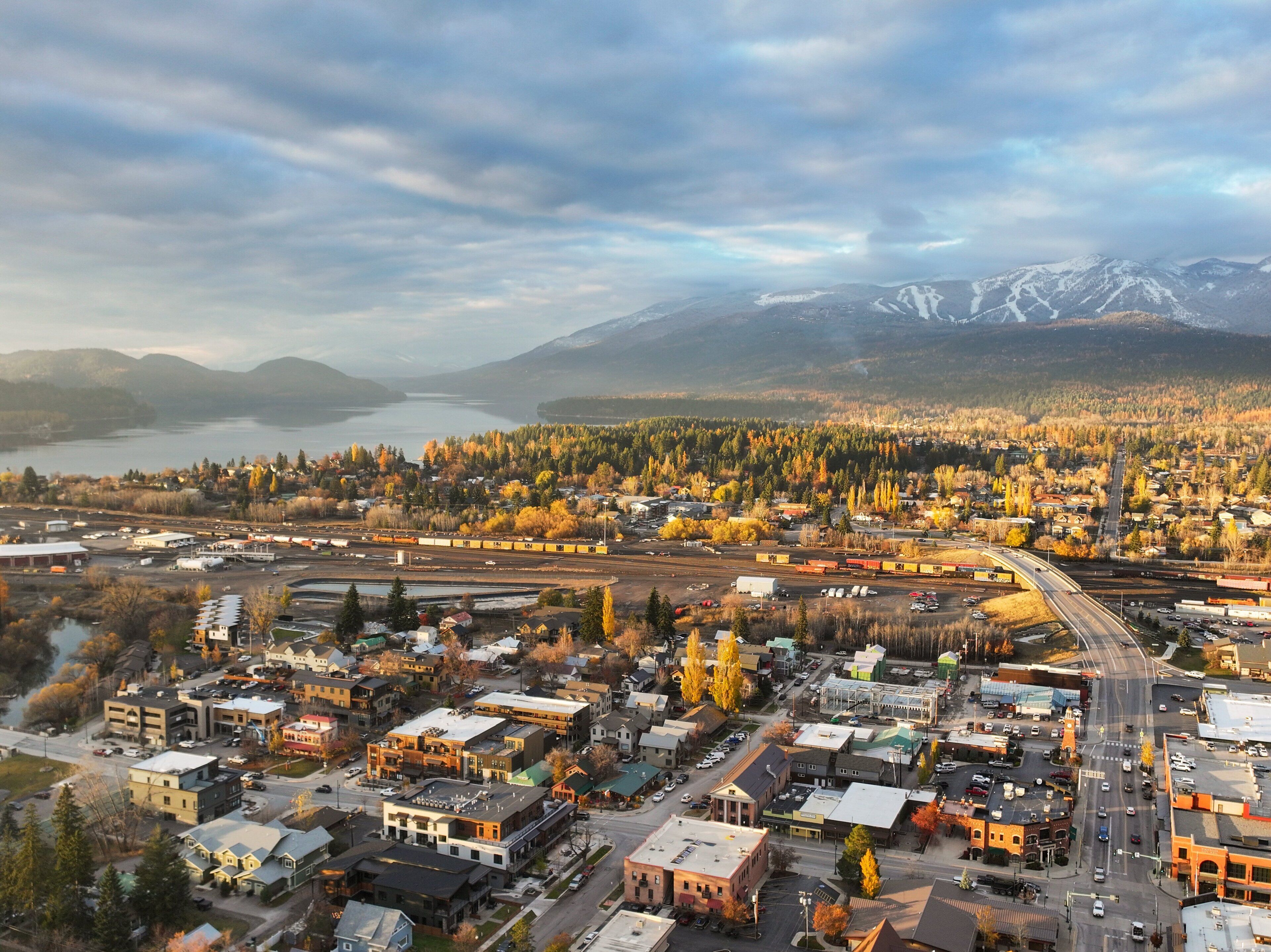 A town with a railway, buildings, and a mountainous backdrop.
