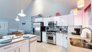 Una cocina moderna con armarios blancos, electrodomésticos de acero inoxidable y encimera de granito.