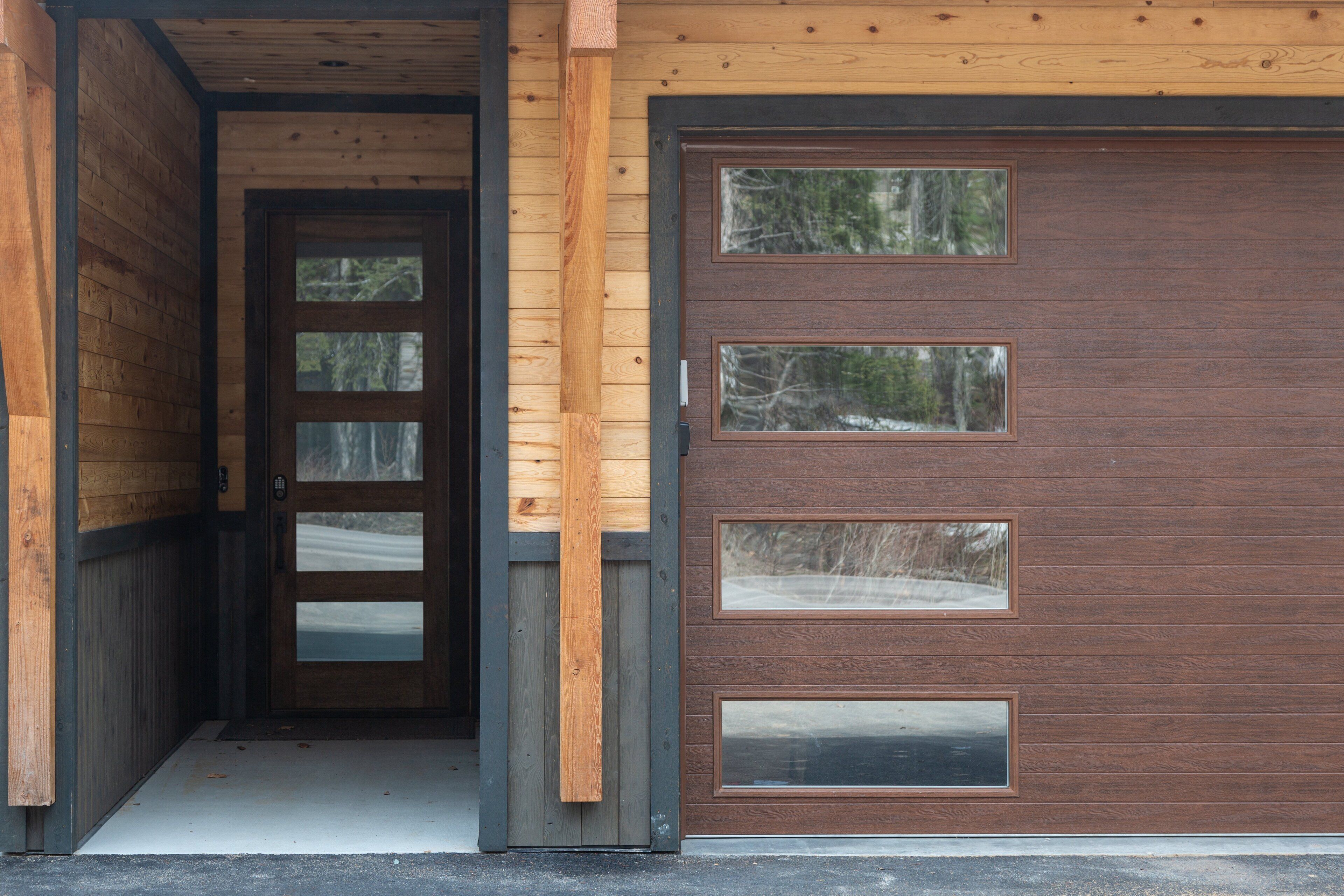 Esterno in legno con un'ampia porta garage e un ingresso.
