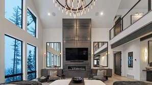 A spacious living room with a large fireplace, a flat-screen TV, and a cozy seating area.
