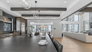 A modern kitchen with a large island, stainless steel appliances, and a view of the outdoors.
