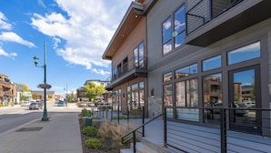 A modern building with large windows, a balcony, and a street view. - Located in Heart Downtown Whitefish, Walking Distance to River + Short Drive to Skiing! (Whitefish)