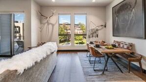 A modern dining area with a wooden table, chairs, and a bench. - Located in Heart Downtown Whitefish, Walking Distance to River + Short Drive to Skiing! (Whitefish)