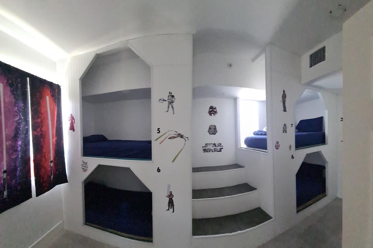 Quarto com beliches, decoração temática de Star Wars e janela com vista.