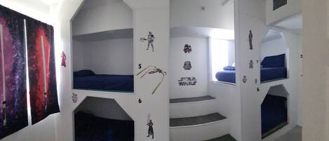 A room with bunk beds, Star Wars decorations, and a window with a view.