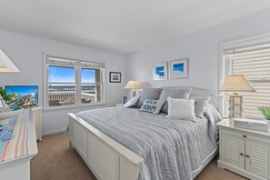 A bedroom with a large bed, a window with a view, a bedside table, and a nightstand. - "Holden 4 Kids" 4 Bedroom, 2 Bathroom, Oceanfront! (Supply)