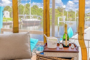Vue depuis le pont d’un bateau, avec une table sur laquelle se trouvent une bouteille de champagne, un seau à glace et des verres.