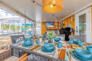 Un coin repas avec une table dressée pour quatre personnes, agrémentée de vaisselle bleue et d’un centre de table en forme d’étoile de mer.